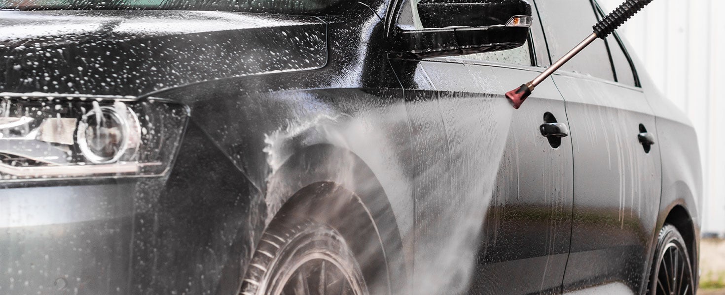 car being rinsed with hose