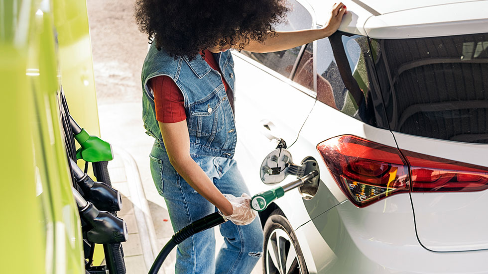 Woman pumping gas with gloves on