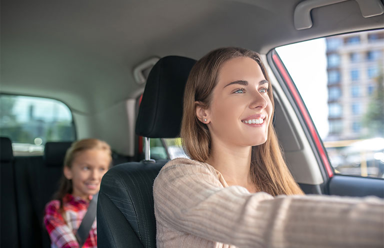 woman diving car, daughter in back seat with seatbelt on