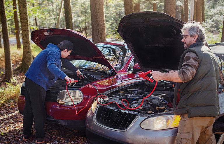 people jump starting a car