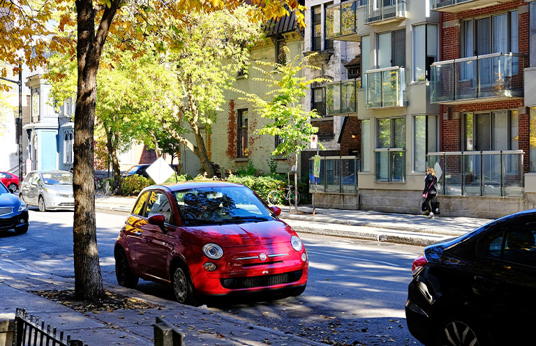 red fiat 500 parked in shade under tree