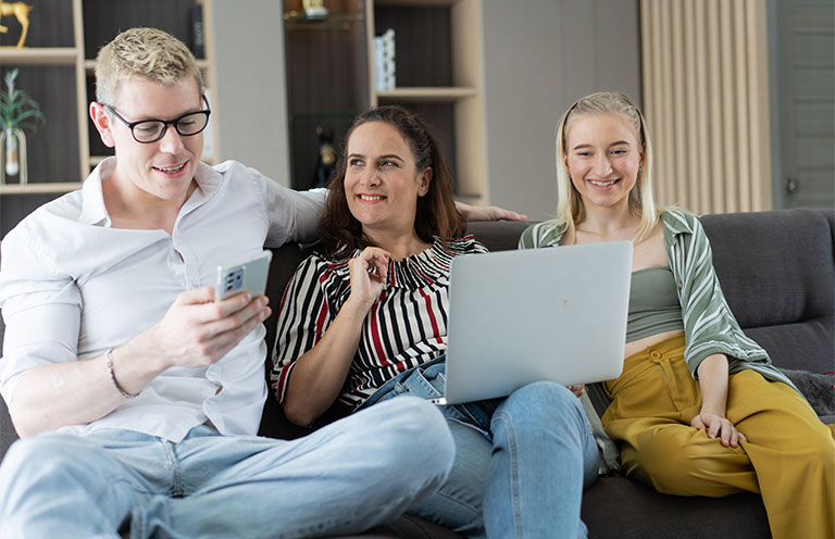 family looking at laptop and phone