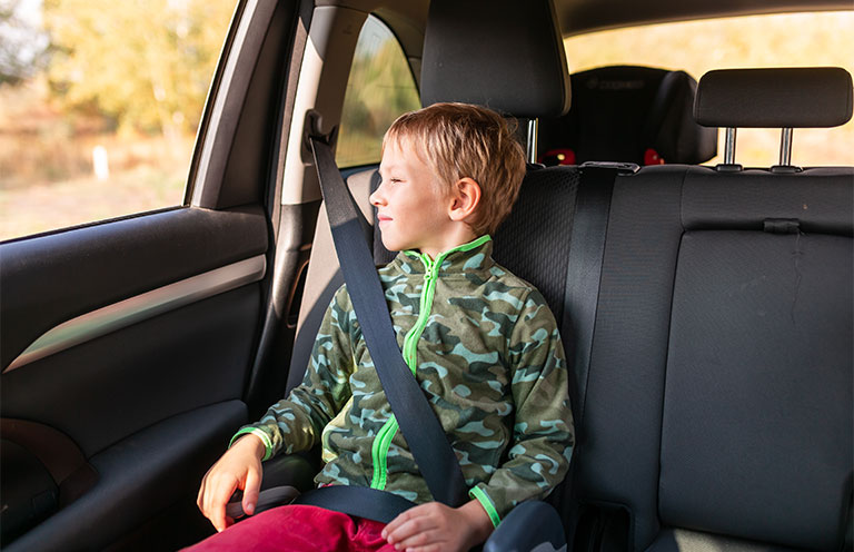 child in booster seat in car
