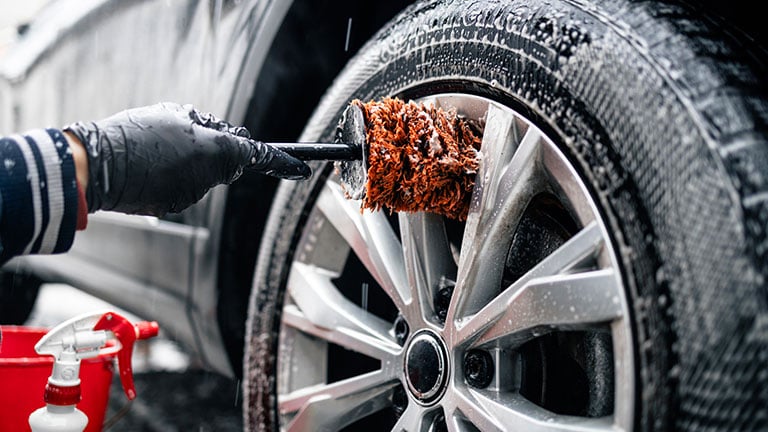 Close up view of car wheel being washed with the brush and soap. Credit:Smederevac