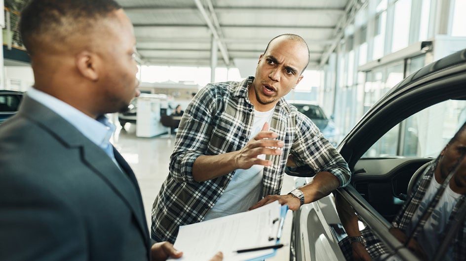 man talking to car salesman