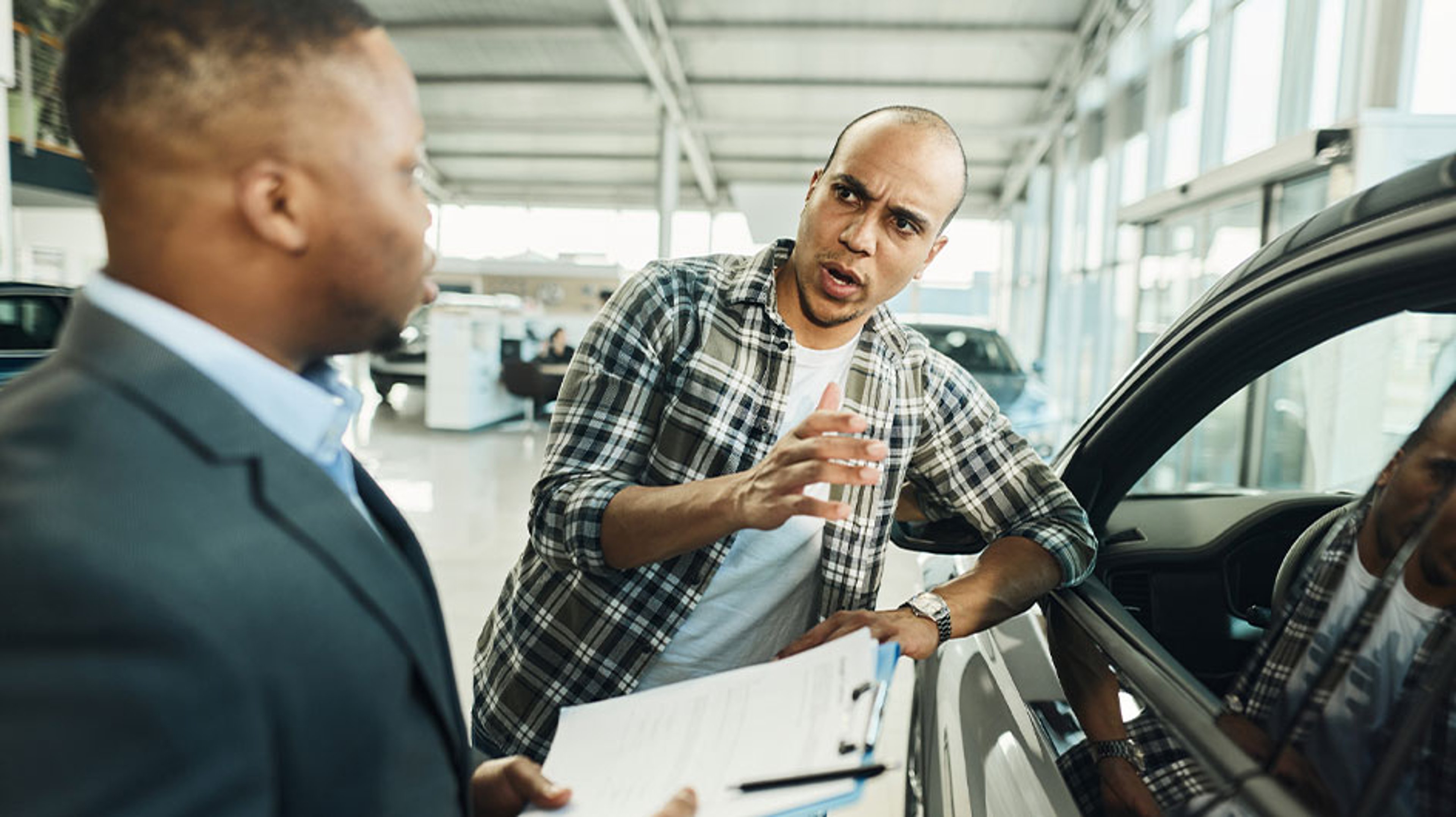 man talking to car salesman