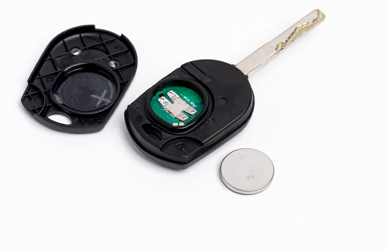 key fob taken apart with battery next to it