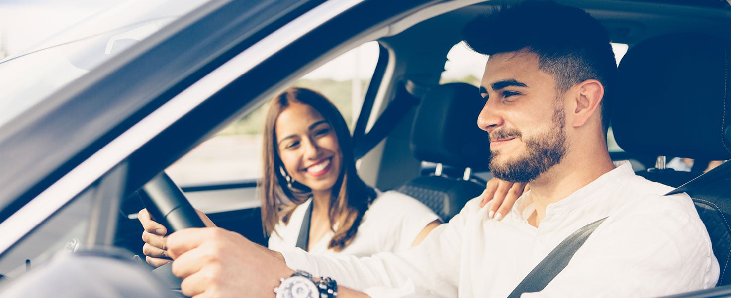 man driving with woman in passenger seat