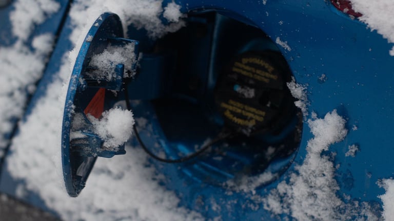 car gas tank cap covered in snow