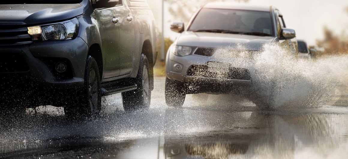 Motion car rain big puddle of water spray from the wheels through flood water after hard rain.Stop action ( capture with the high speed shutter) and selective focus.Color toned; By chokchaipoo