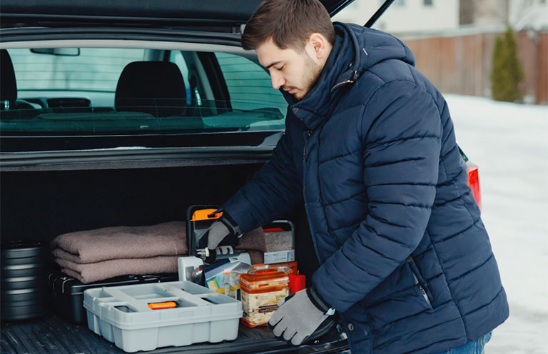 man putting items in trunk of car