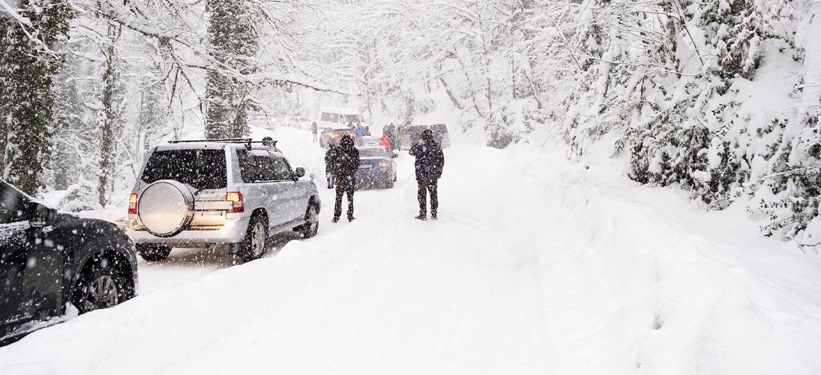 people and cars stuck on snowy road