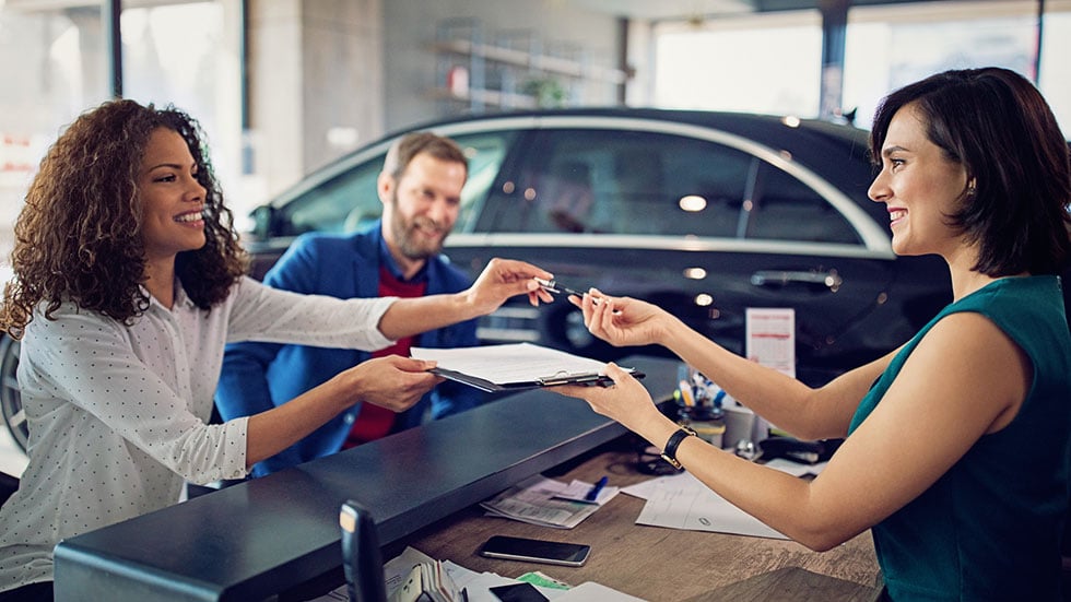 Couple is buying new car and signing the contract