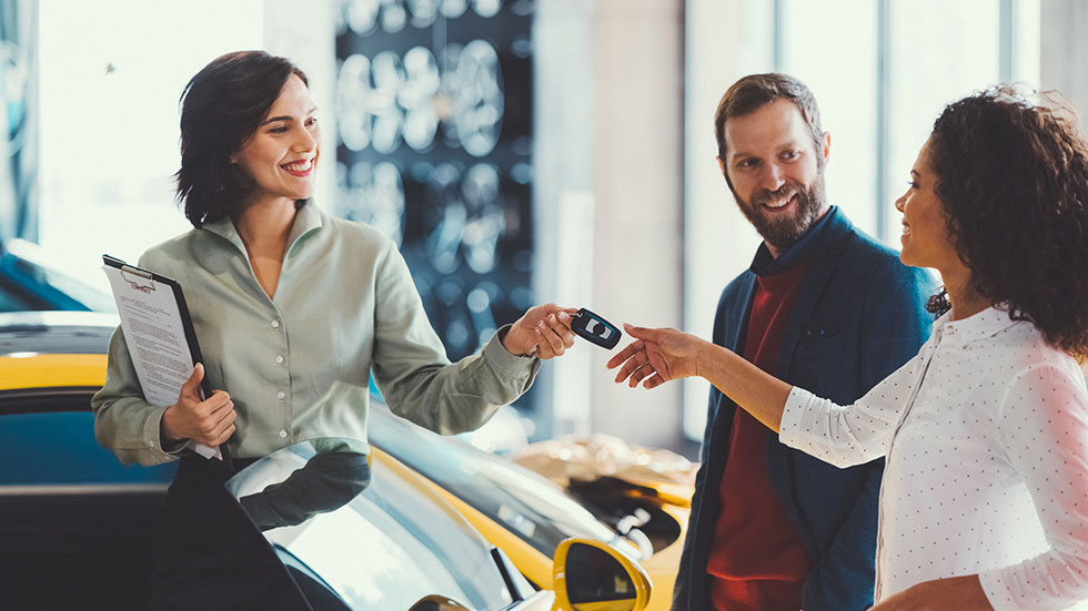 Young man surprising his wife with buying a new car