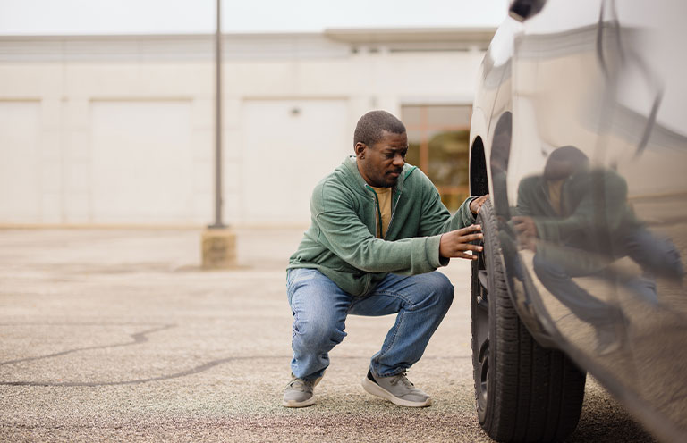 man visually inspecting tire