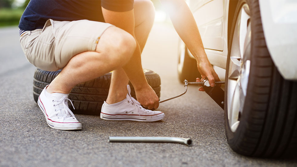 man using jack and changing tire