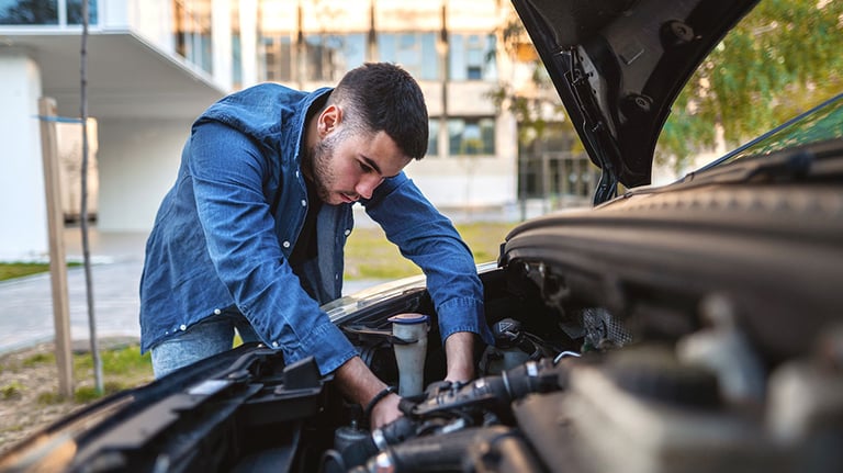 Young man fixing his car engine. Credit: Viktor Cvetkovic
