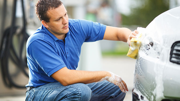 A woman cleaning a car with a microfiber cloth Credit: ISMOLOEX