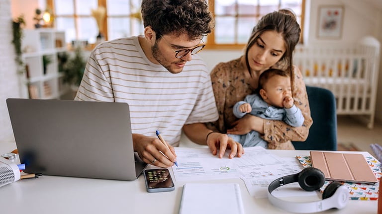 Young family with cute little baby boy going over finances at home