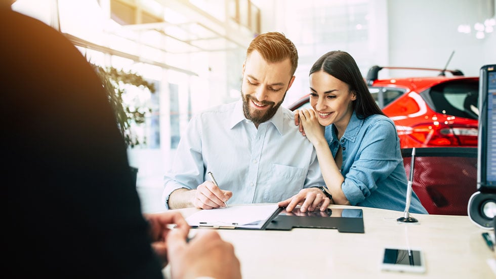 Couple signing documents for a new car