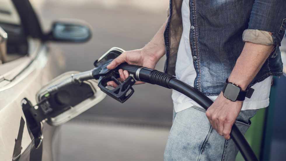 man about to place gas nozzle into gas tank 