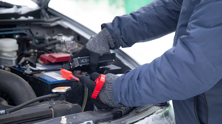 person using jumper cable on car