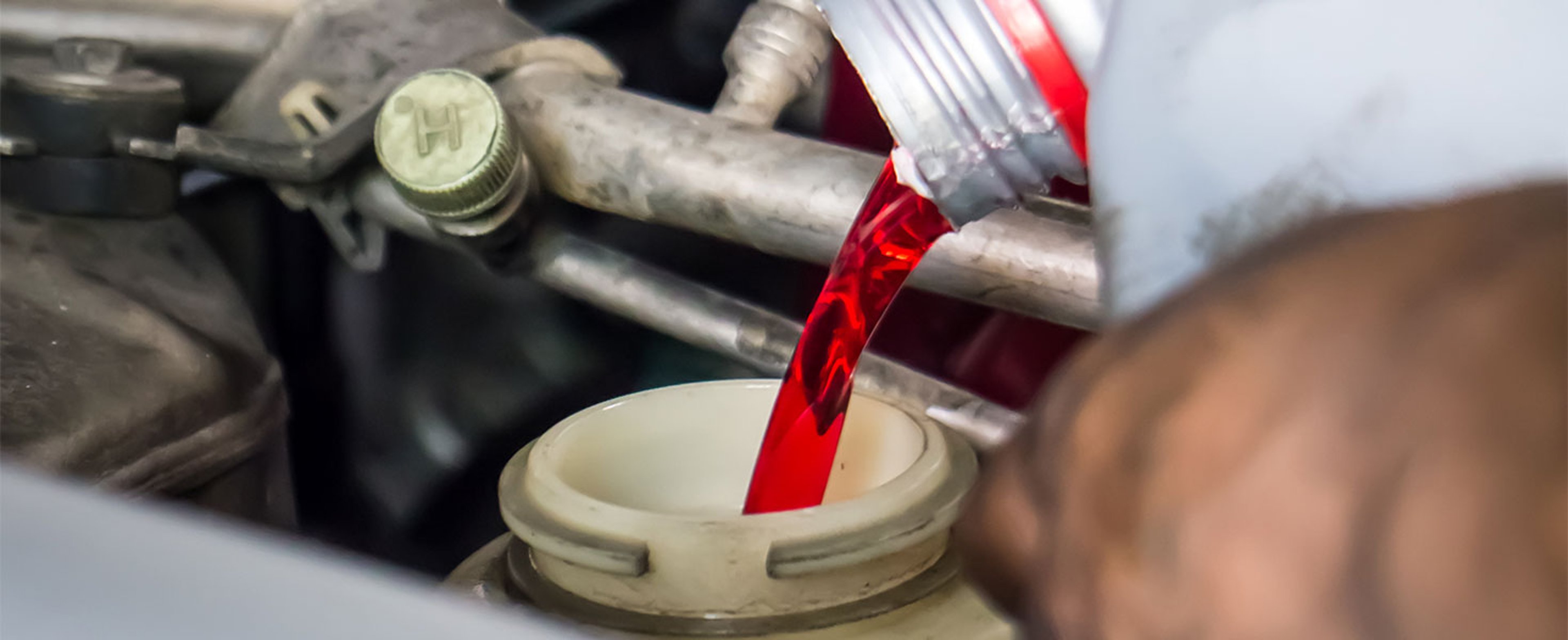 person adding transmission fluid