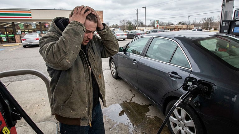 A realistic photo of a person at a gas station The person is pumping gas into a car the gas Created with Runway AI