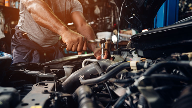 Young hispanic men working on a vintage lowrider car in a home driveway. Credit:O2O Creative