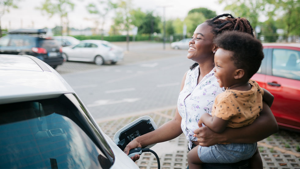 mom getting gas holding kid