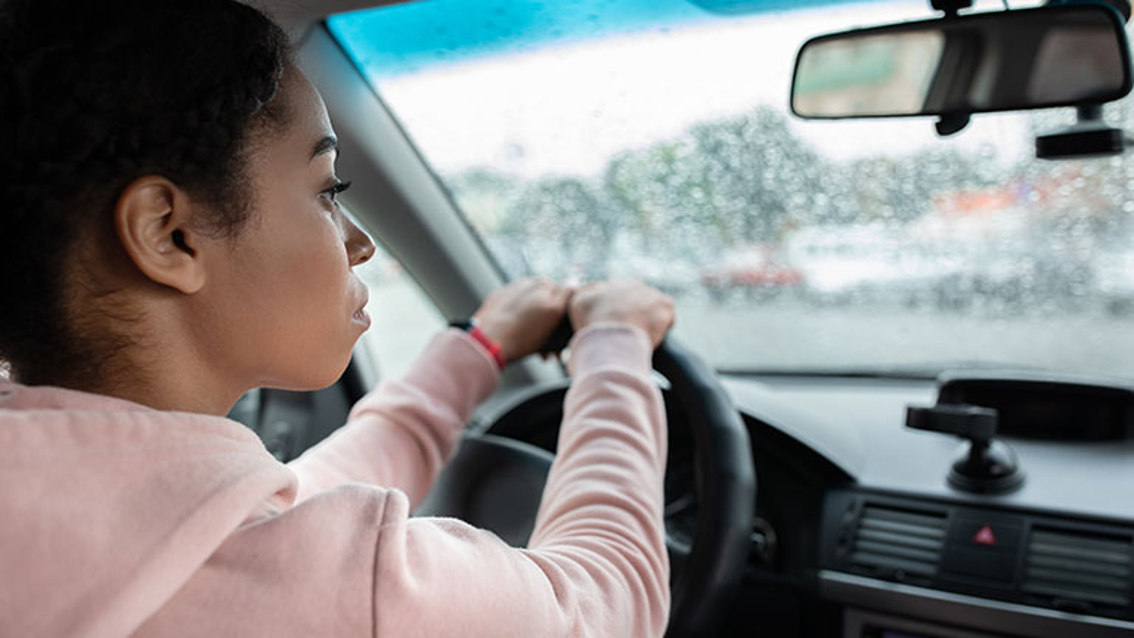 Working as taxi driver in city in bad rainy weather and way to job By Prostock-studio