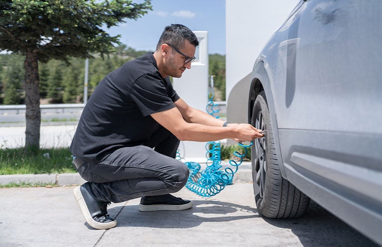 adding air to car tire