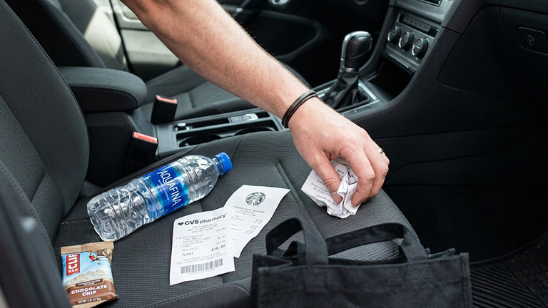 Photograph of a the inside of a car having trash cleaned