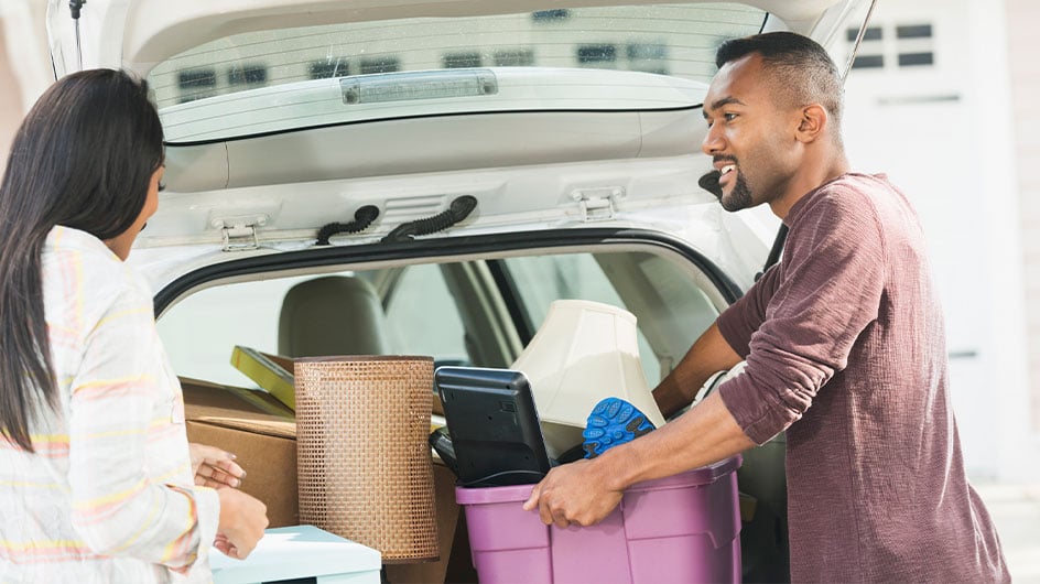man and woman clearing out car trunk
