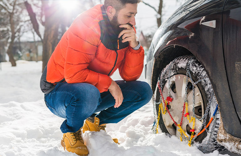 man adding chains to car tires