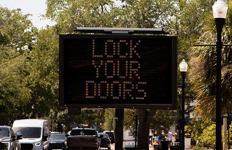 digital sign in neighborhood that says lock your doors