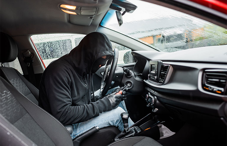 man trying to start car with screwdriver