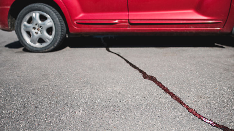 A stream of liquid on the pavement from under the car - oil flows from the engine Credit:andreygonchar