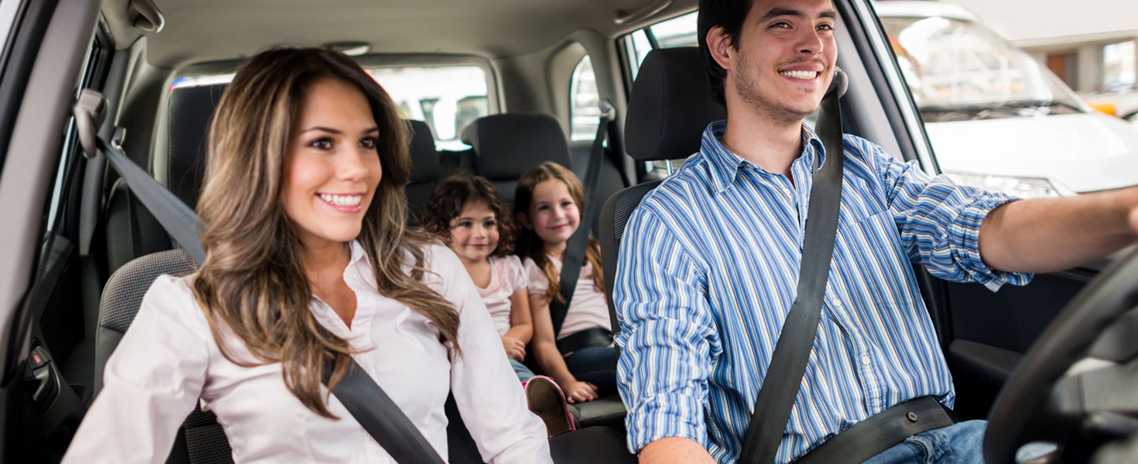 Family driving a car and looking very happy