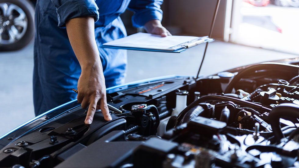 Mechanic looking under hood of car