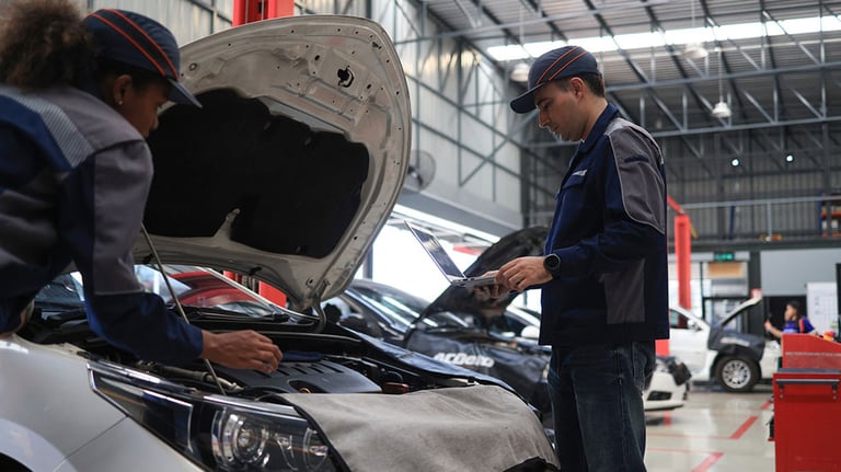 Foreman and female technician discussing car maintenance plan and progress in car service center , professional mechanic discussing car repair. Credit: onuma Inthapong