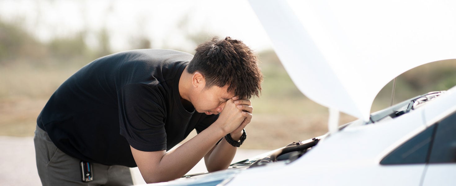 Worried asian young man stands in front of car checking condition after a broken car. Broken car down on the road. emergency service has broken car