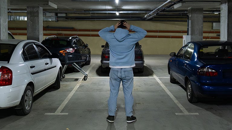Person in Underground Parking Garage Figure Out of Stolen Car copy space Credit:Vera_Petrunina