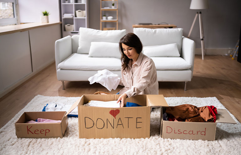 woman sorting items to keep donate or throw away
