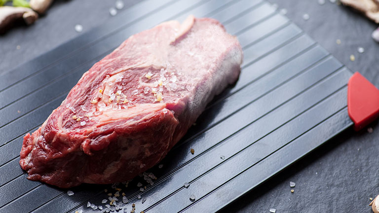 raw steak on defrosting tray. The steak is half frozen and half thawed. Credit:Katelin Kinney