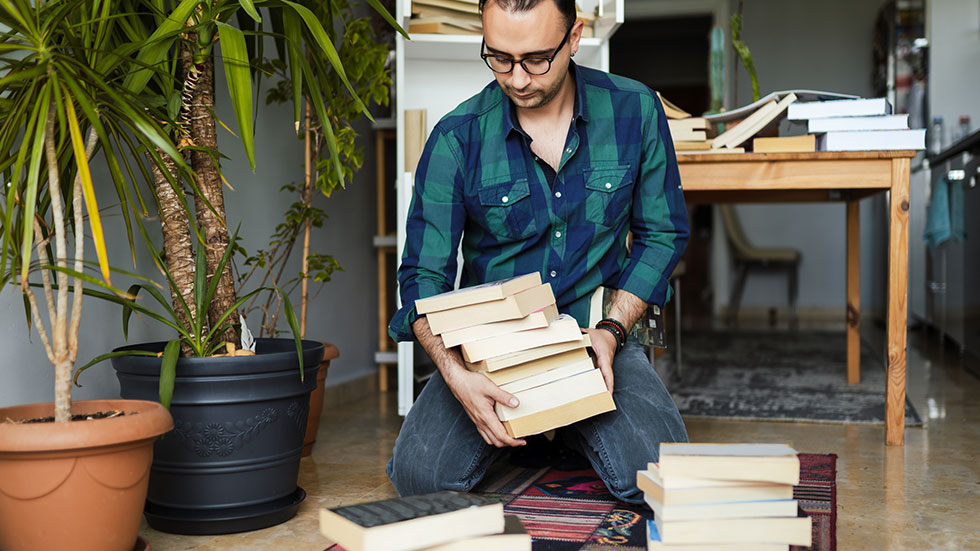 Millennial man organizing his book collections