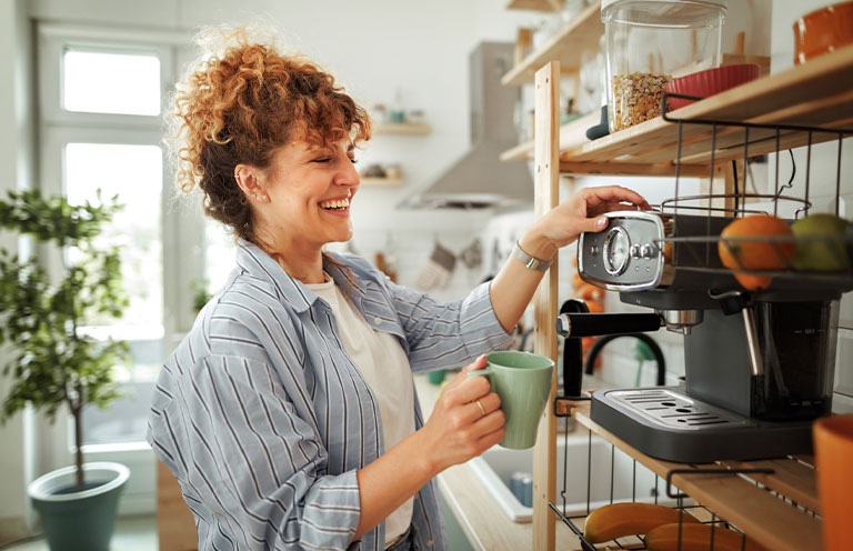woman putting mug on coffee maker