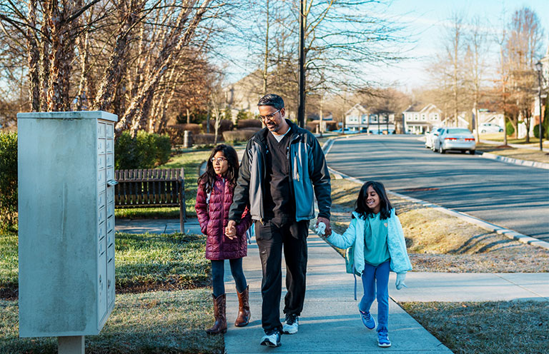man walking with daughters in neighborhood