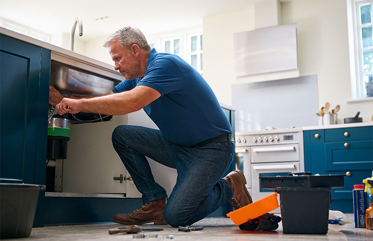 man fixing garbage disposal