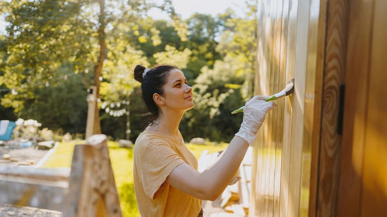Woman adding clear coat to outside sidings